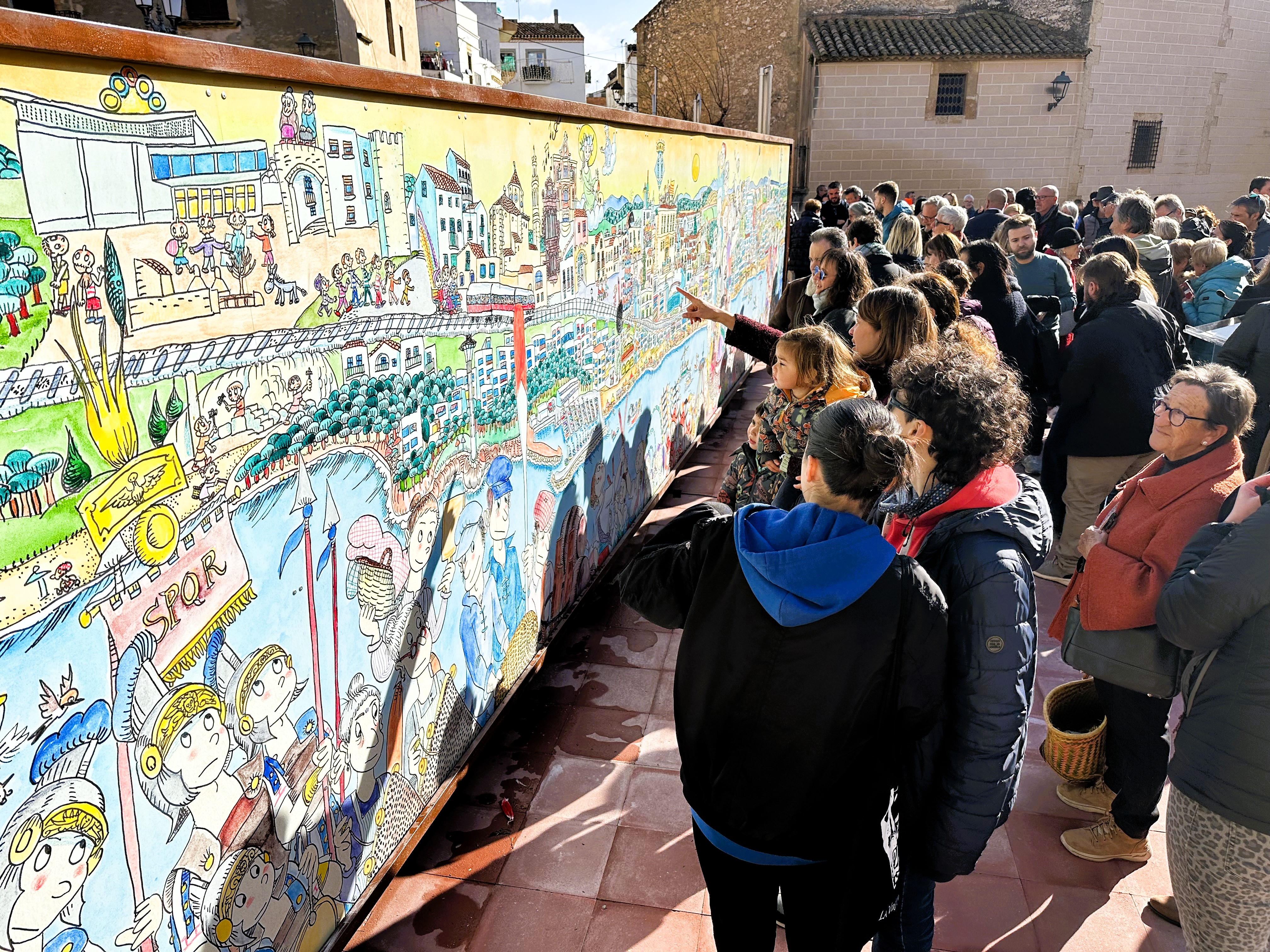 Públic assistent a la inauguració, observant els detalls del mural