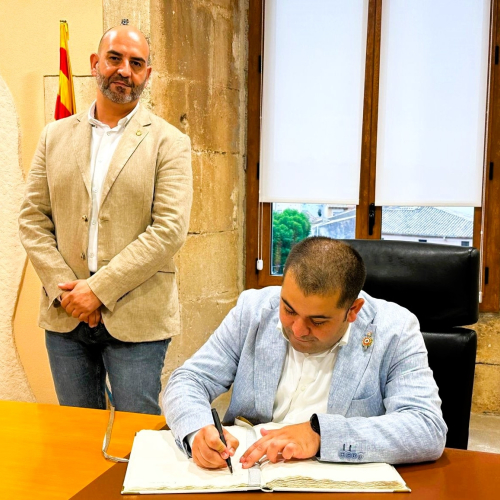 L'alcalde de Villars, Jordan Da Silva, signant el Llibre d'Or, acompanyat per l'alcalde de la Torre, Vale Pino