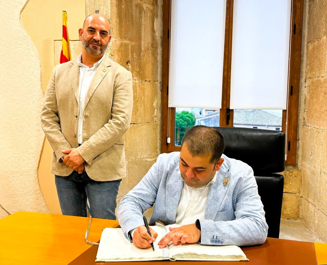 L'alcalde de Villars, Jordan Da Silva, signant el Llibre d'Or, acompanyat per l'alcalde de la Torre, Vale Pino