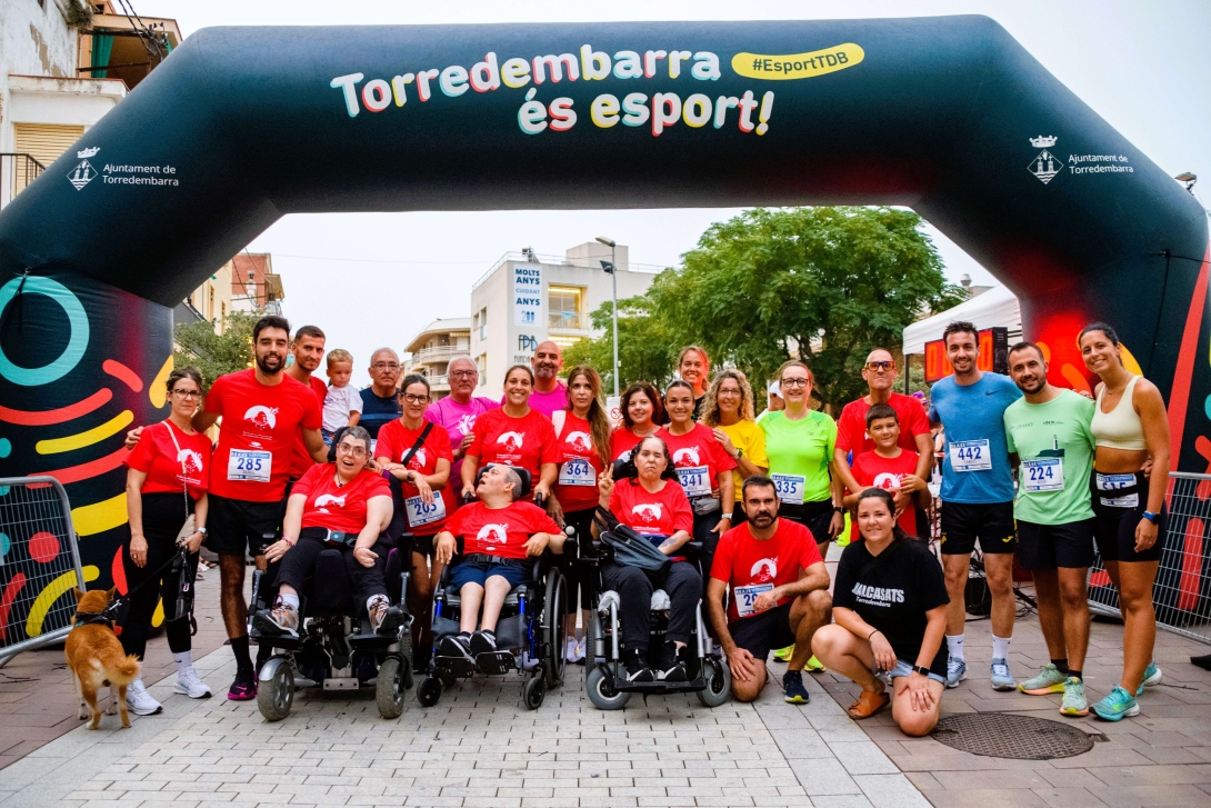 Usuaris i usuàries de la Fundació La Muntanyeta, amb els organitzadors, a la sortida de la cursa